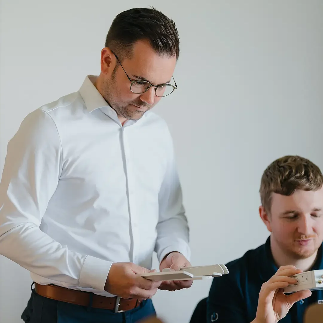 Geschäftsführer und Mitarbeiter von EXPLETO prüfen gemeinsam technische Hardware und Komponenten bei der Vorbereitung von IT-Lösungen.